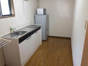 a kitchen with a sink and a refrigerator at Guest House Kiyohime in Tanabe