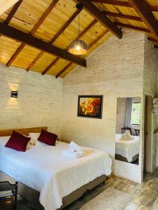 a bedroom with two beds in a room at Chalé Recanto dos Pinheiros in Monte Verde