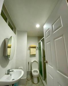 a bathroom with a toilet and a sink and a mirror at The Nearest Studio from MactanAirport with Disney+ in Pusok