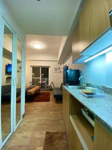 a kitchen with a counter top and a living room at The Nearest Studio from MactanAirport with Disney+ in Pusok