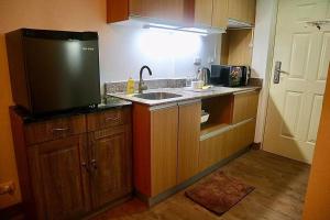 a small kitchen with a sink and a refrigerator at The Nearest Studio from MactanAirport with Disney+ in Pusok