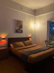 ein Schlafzimmer mit einem Bett mit zwei Leuchten in der Unterkunft The Nearest Studio from MactanAirport with Disney+ in Pusok