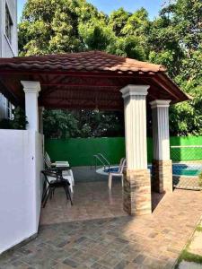 - un pavillon avec une table et un banc sur une terrasse dans l'établissement Residencial joyas d’ luxe lll, à Santiago de los Caballeros