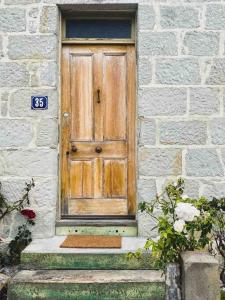 una puerta de madera en un edificio de piedra con escalones en The Shooters Cottage Bellerive I Circa 1830, en Bellerive