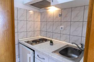 a small kitchen with a sink and a stove at Apartments Julijana in Makarska