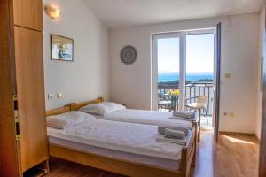 a bedroom with a bed and a balcony at Apartments Julijana in Makarska