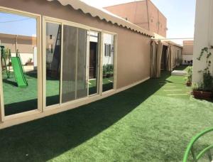 a house with a lawn with green grass at Modernistic Antique Stay in Jeddah