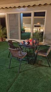 a patio with a table and chairs on the grass at Modernistic Antique Stay in Jeddah
