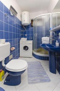 een blauw betegelde badkamer met een toilet en een wastafel bij Apartments Nada in Vodice