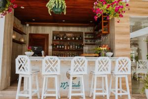 Eine Bar mit weißen Barhockern vor einem Tresen in der Unterkunft Montañablu Hotel in Montañita