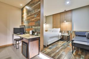 金海市Gracias Hotel Gimhae的配有床和书桌的酒店房间