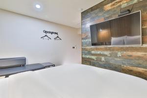 um quarto com uma grande televisão na parede em Gracias Hotel Gimhae em Gimhae