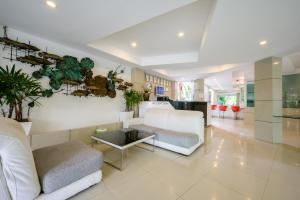 een woonkamer met een witte bank en een tafel bij Cozy Resort, A Boutique Hotel in Pattaya South