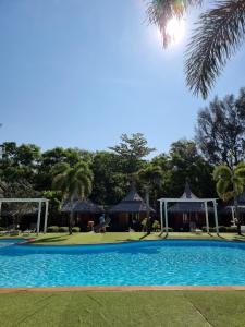 a blue swimming pool with a gazebo at Phayam Cottage Resort in Ko Phayam