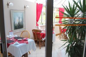 a dining room with a table and a plant at Boland's Accommodation Dingle in Dingle