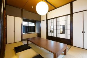 Zimmer mit einem Holztisch und einem Fenster in der Unterkunft push house 伊東 in Ito
