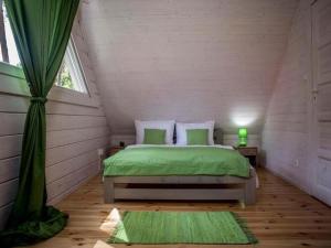 a bedroom with a green bed in a attic at Comfortable, two-story holiday houses, Pobierowo in Pobierowo