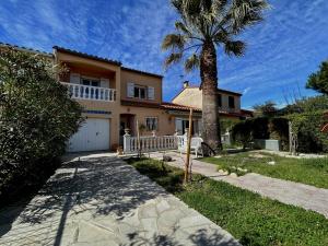 a house with a palm tree and a driveway at Sublime Villa Climatisée Familiale avec Extérieurs Spacieux – Quartier Calme - FR-1-388-215 in Argelès-sur-Mer