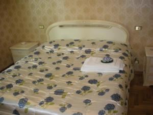 Una cama blanca con flores azules. en Agriturismo Le Rose, en Castiglione del Lago