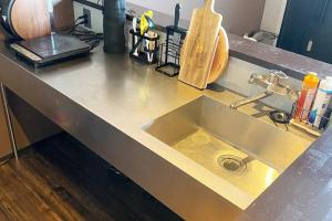 a kitchen counter with a stainless steel sink at Tiny resort misawa in Misawa