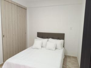 1 dormitorio con cama blanca y almohadas blancas en Espectacular apartamento en Cali zona sur 3B, en Cali