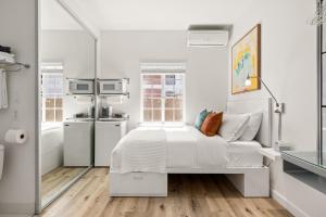 a white bedroom with a bed and a kitchen at The Varden - A Boutique Micro Hotel - #25 in Long Beach