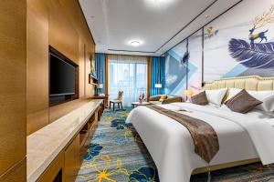 ein Hotelzimmer mit einem großen Bett und einem Flachbildfernseher in der Unterkunft QingMan Apartment Guangzhou Zhujiang New Town East Railway Station Branch in Guangzhou