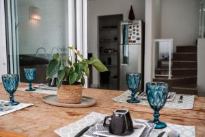 a table with blue glasses and a potted plant on it at Casa Jangada Camocim in Camocim