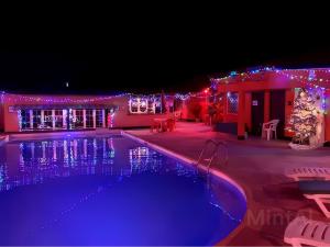 une maison avec une piscine aux lumières de Noël dans l'établissement Avalon Garden Lodge, à Banjul