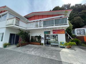a white building with a balcony on top of it at Peppertree Lodge & Backpackers in Paihia