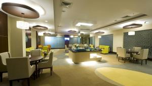 a restaurant with tables and chairs and a waiting room at Emerald Garden International Hotel in Medan
