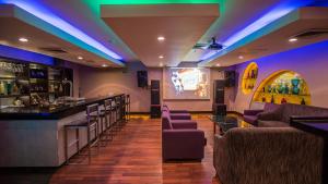 a bar with purple and green lights in a restaurant at Emerald Garden International Hotel in Medan