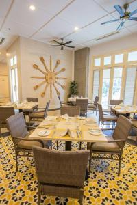 a dining room with tables and chairs and a large clock at Emerald Garden International Hotel in Medan