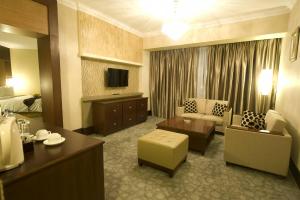 a hotel room with a couch and a table at Emerald Garden International Hotel in Medan