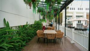 an outdoor patio with a table and chairs and plants at Emerald Garden International Hotel in Medan