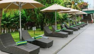 a row of chairs and umbrellas at a resort at Emerald Garden International Hotel in Medan