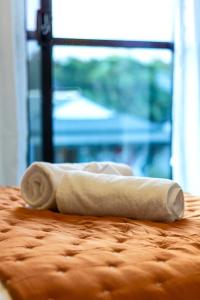 a rolled up towel sitting on top of a bed at Modern 3 bed overlooking Hagley Park in Christchurch