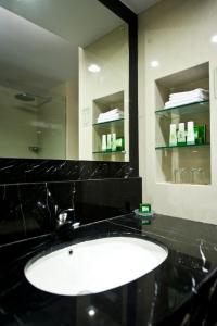 a bathroom with a sink and a mirror at Emerald Garden International Hotel in Medan