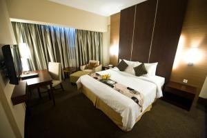 a hotel room with a large bed and a desk at Emerald Garden International Hotel in Medan