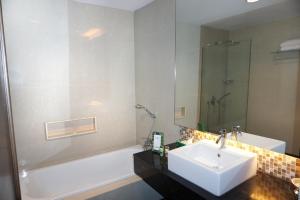 a bathroom with a sink and a tub and a shower at Emerald Garden International Hotel in Medan