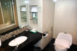 a bathroom with a sink and a toilet at Emerald Garden International Hotel in Medan
