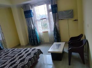 a bedroom with a bed and a desk and a window at Mahamaya Homestay 4 in Mandi