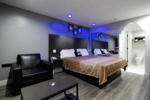 a bedroom with a bed and a black chair at Downtowner Inns - Houston Downtown & Convention Center in Houston