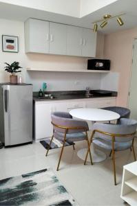 a kitchen with a table and chairs and a refrigerator at Cozy Flexi 1BR or 2BR condo at Southmall Las Pinas in Manila