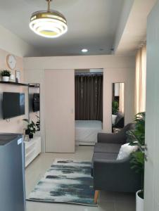 a living room with a couch and a tv at Cozy Flexi 1BR or 2BR condo at Southmall Las Pinas in Manila