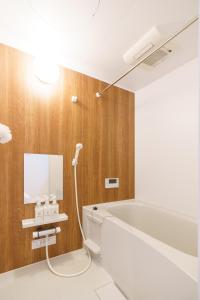 a bathroom with a bath tub and a mirror at 自由自在OSU 501(SORA) in Nagoya
