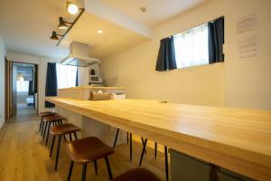名古屋的住宿－自由自在OSU 501(SORA)，一个带凳子的房间里的一个大型木制酒吧