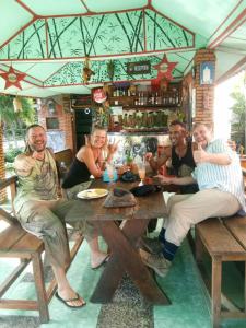 a group of people sitting around a wooden table at Lucky Bamboo'Bungalows-Resto and Orangutan Jungle Trekking Tours in Bukit Lawang