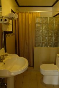 y baño con lavabo, aseo y ducha. en Villa Italia Hotel en Sorsogon