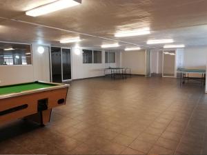 an empty room with a pool table and tables at Santorini Unit R in Margate